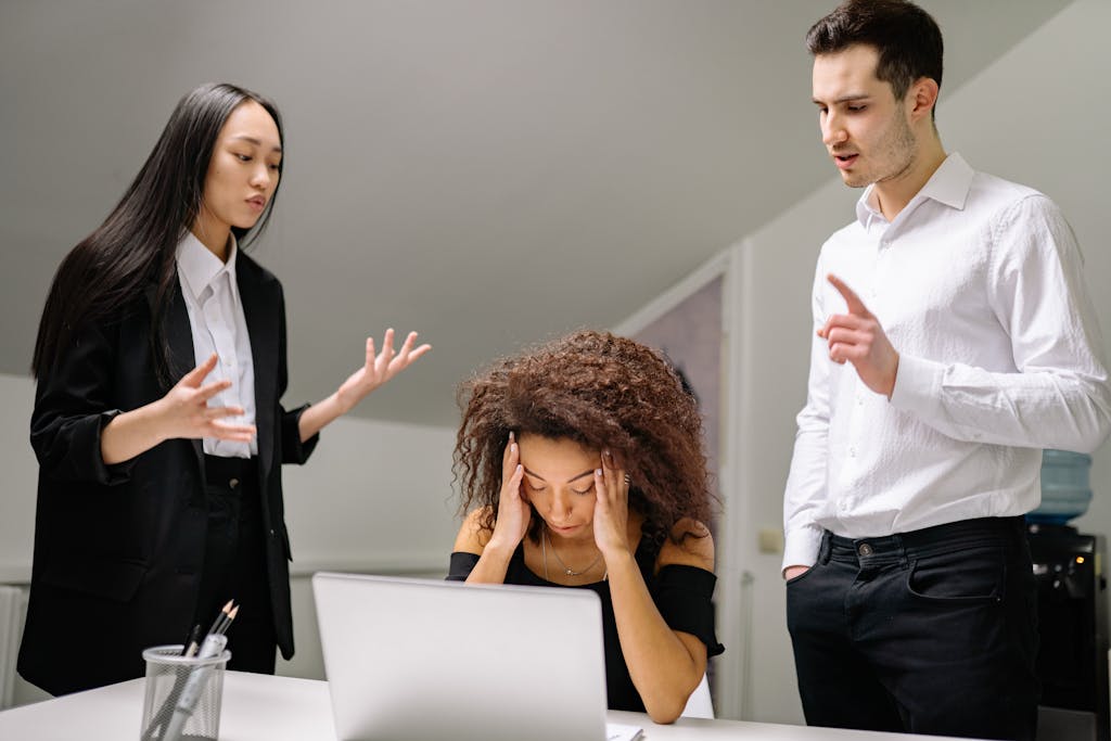 new manager skills, Diverse coworkers in an office dealing with a stressful work situation around a laptop.