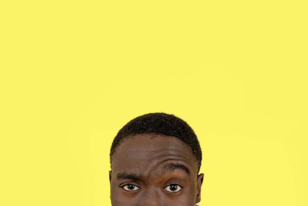 Close-up of a man's face with a thoughtful expression against a yellow background reflecting on leadership lessons