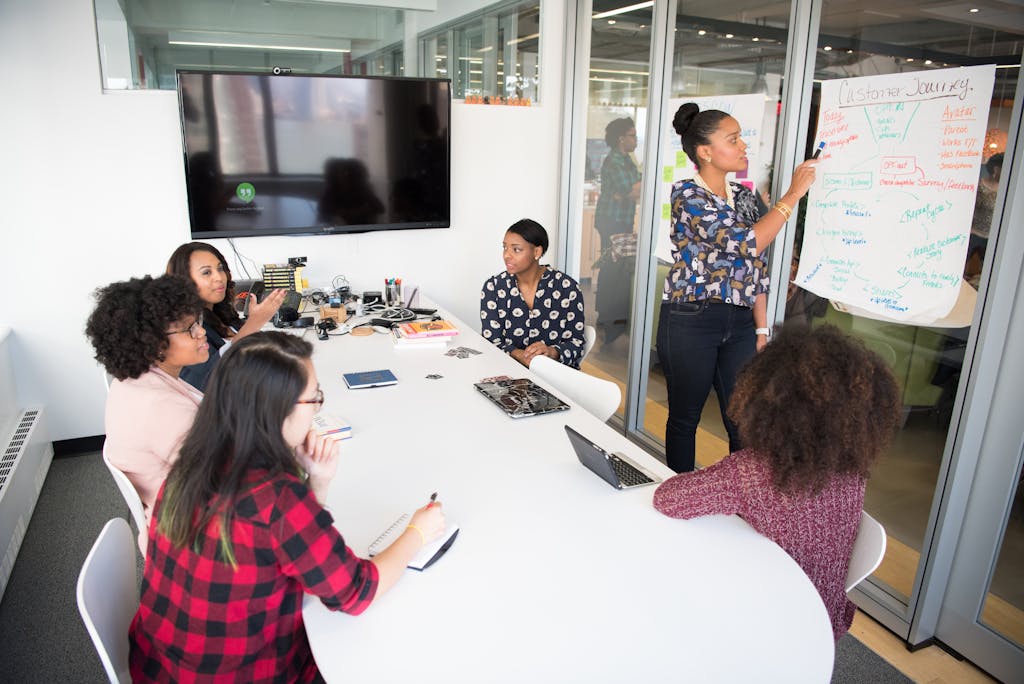 A multicultural office team engages in collaborative problem solving around meeting table.